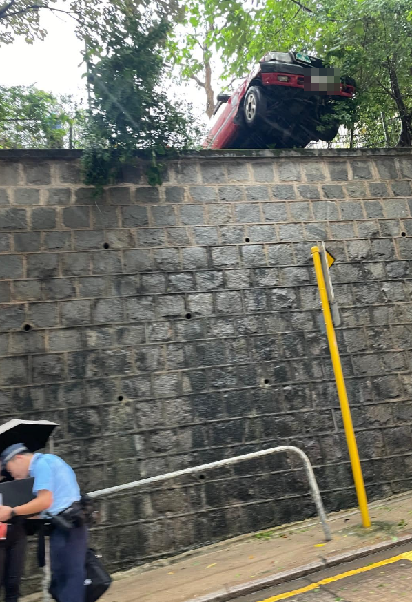 涉事的士車頭懸空擱於石壆上,車尾升起離地