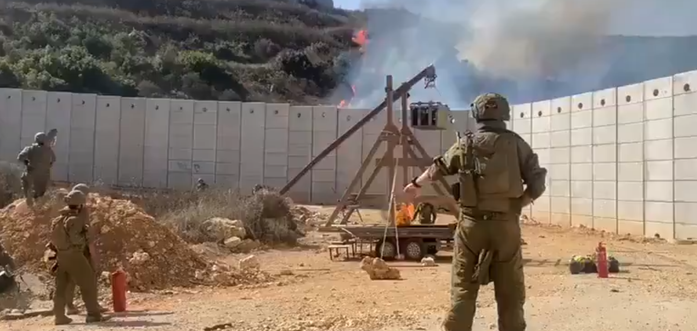 以色列士兵以一座投石機,不斷對圍牆另一邊投擲燃燒彈(社交平台X影片)