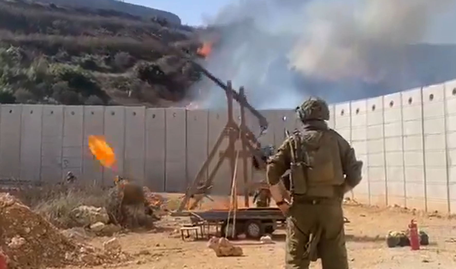 以色列士兵以一座投石機,不斷對圍牆另一邊投擲燃燒彈(社交平台X影片)