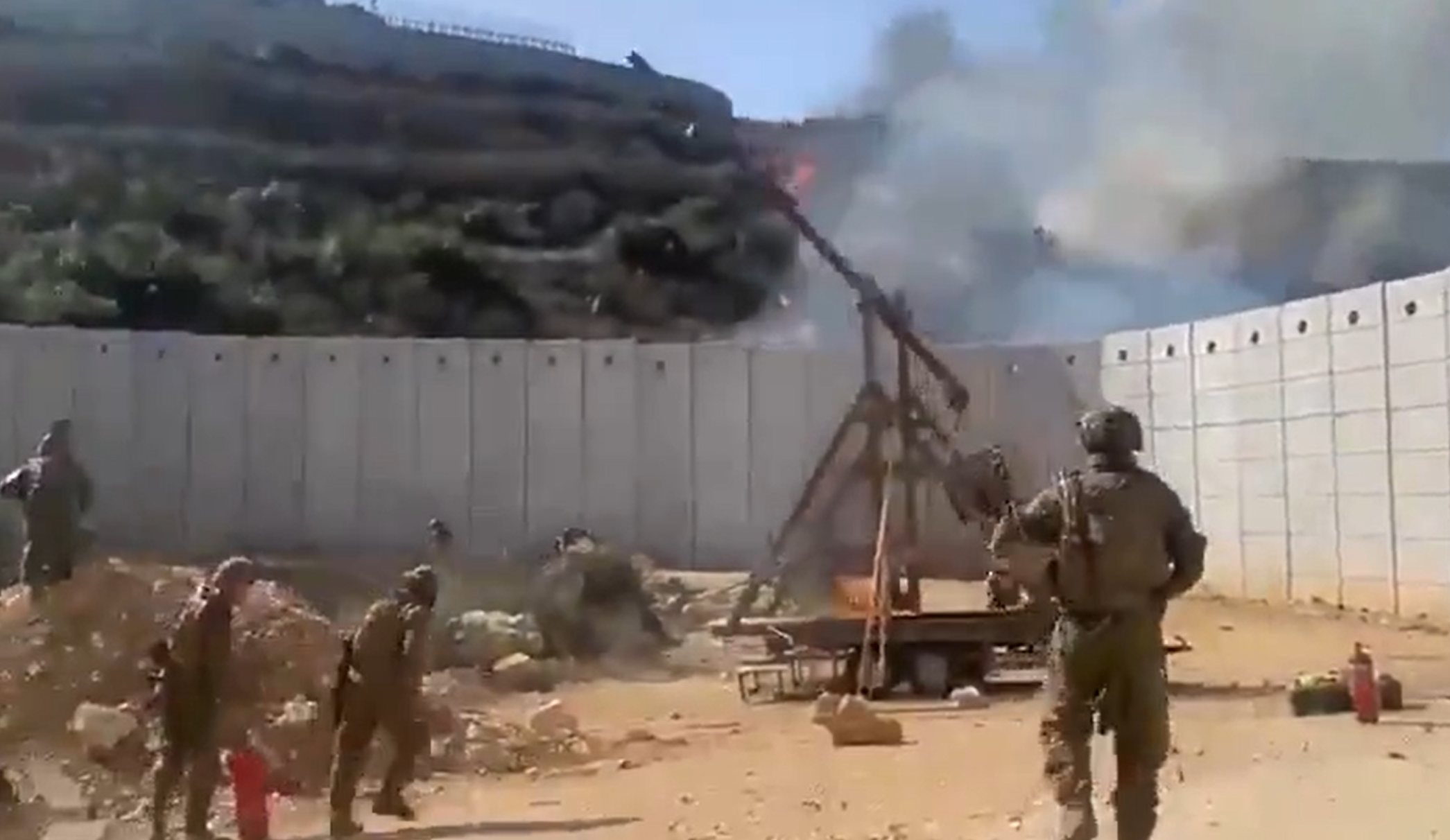 以色列士兵以一座投石機,不斷對圍牆另一邊投擲燃燒彈(社交平台X影片)