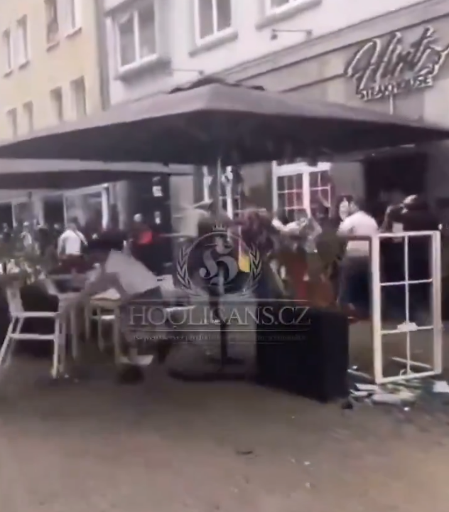歐洲國家盃|網上片段顯示,在一間掛有塞爾維亞國旗的餐廳外,兩批男子互相打鬥子,期間有人用座椅作攻擊武器,亦有人投擲玻璃杯。(影片截圖)