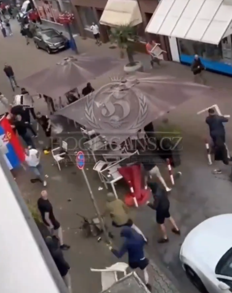 歐洲國家盃|網上片段顯示,在一間掛有塞爾維亞國旗的餐廳外,兩批男子互相打鬥子,期間有人用座椅作攻擊武器,亦有人投擲玻璃杯。(影片截圖)