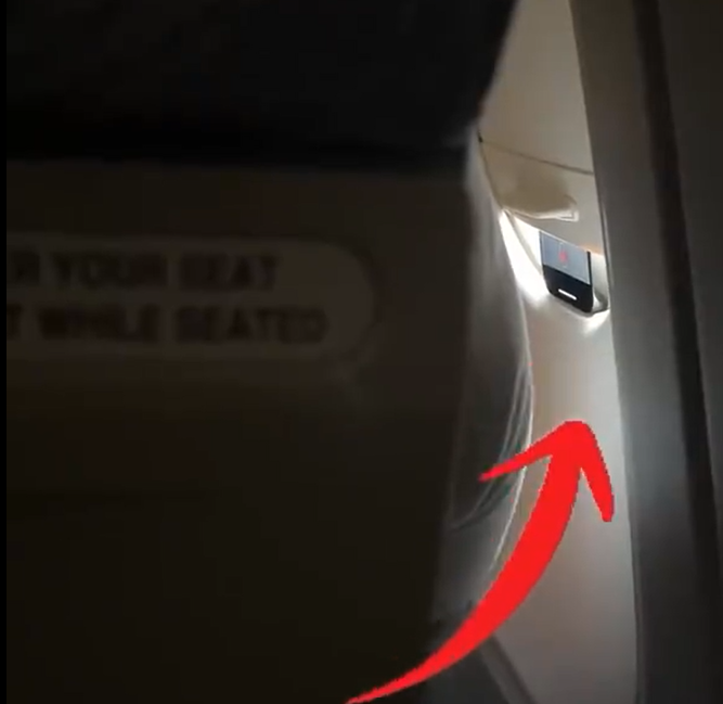 浙江省義烏市一架飛往北京市的客運航班上,有民眾目睹前排一名外國乘客將手機卡在遮光板,疑似偷拍軍民合用的機場,隨即他向國安部門舉報。(影片截圖)