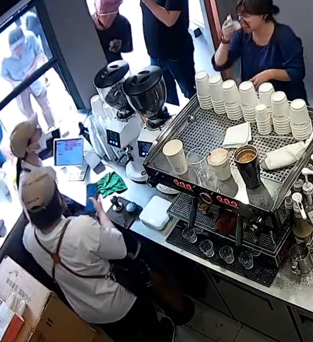 上海「網紅」咖啡店Manner Coffee有女店員與女客人爭執期間突然情緒失控,將整杯咖啡粉兜頭潑向客人面上並嚎叫「你投訴呀」。(影片截圖)