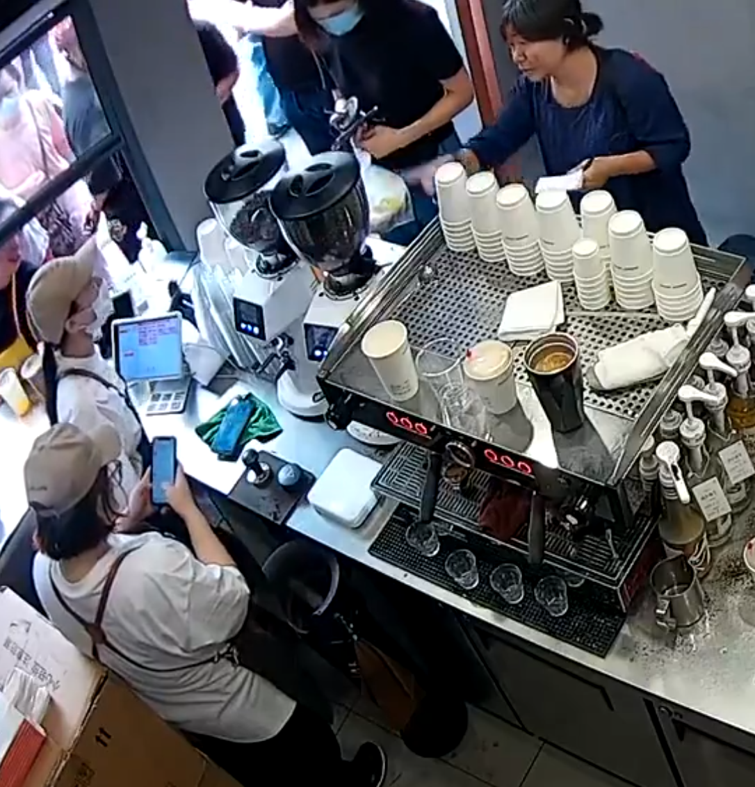 上海「網紅」咖啡店Manner Coffee有女店員與女客人爭執期間突然情緒失控,將整杯咖啡粉兜頭潑向客人面上並嚎叫「你投訴呀」。(影片截圖)