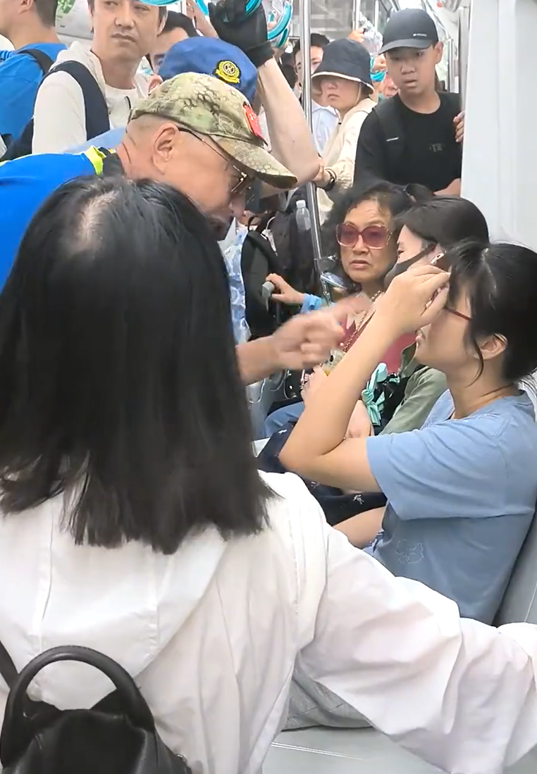 北京地鐵一名老翁不滿女乘客拒讓座,用枴杖狂撩女子雙腿中間來回「橫掃」。(影片截圖)