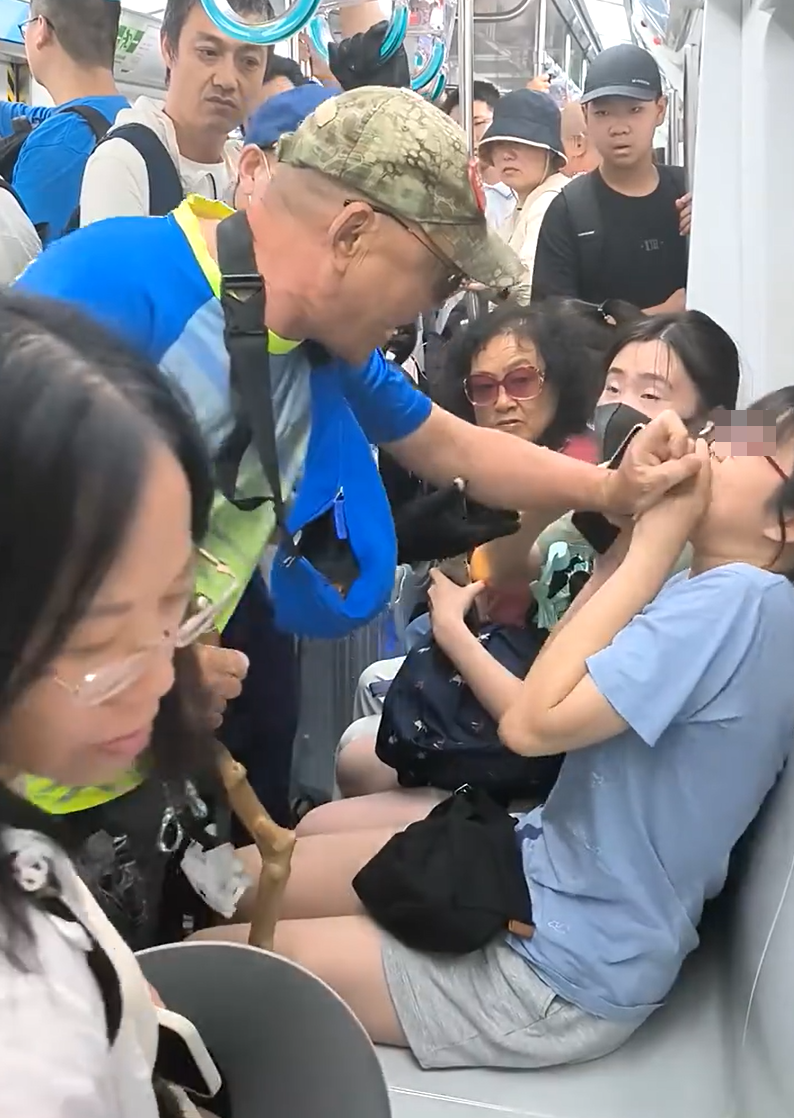 北京地鐵一名老翁不滿女乘客拒讓座,用枴杖狂撩女子雙腿中間來回「橫掃」。(影片截圖)