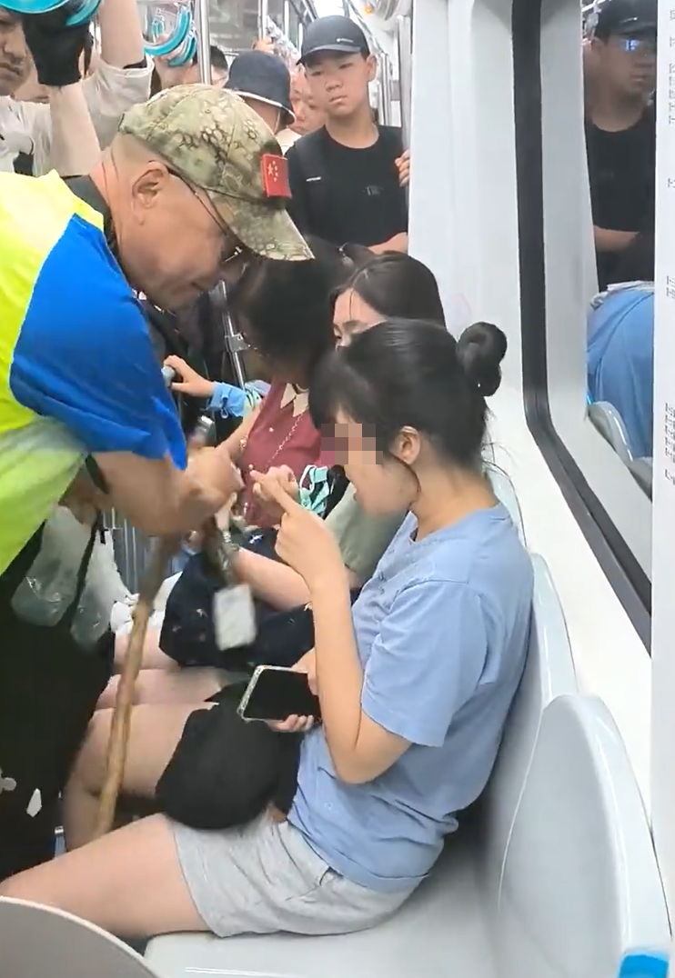 北京地鐵一名老翁不滿女乘客拒讓座,用枴杖狂撩女子雙腿中間來回「橫掃」。(影片截圖)