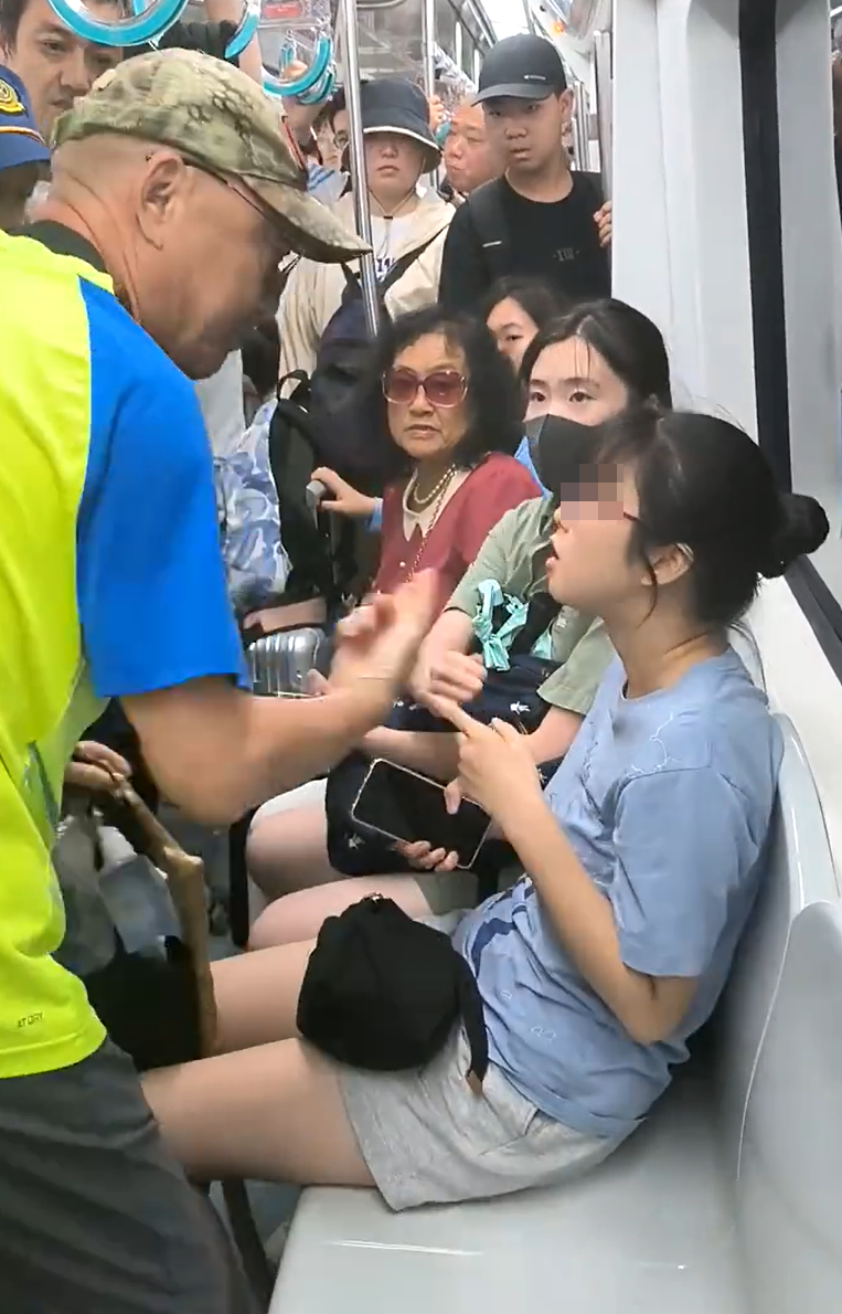 北京地鐵一名老翁不滿女乘客拒讓座,用枴杖狂撩女子雙腿中間來回「橫掃」。(影片截圖)