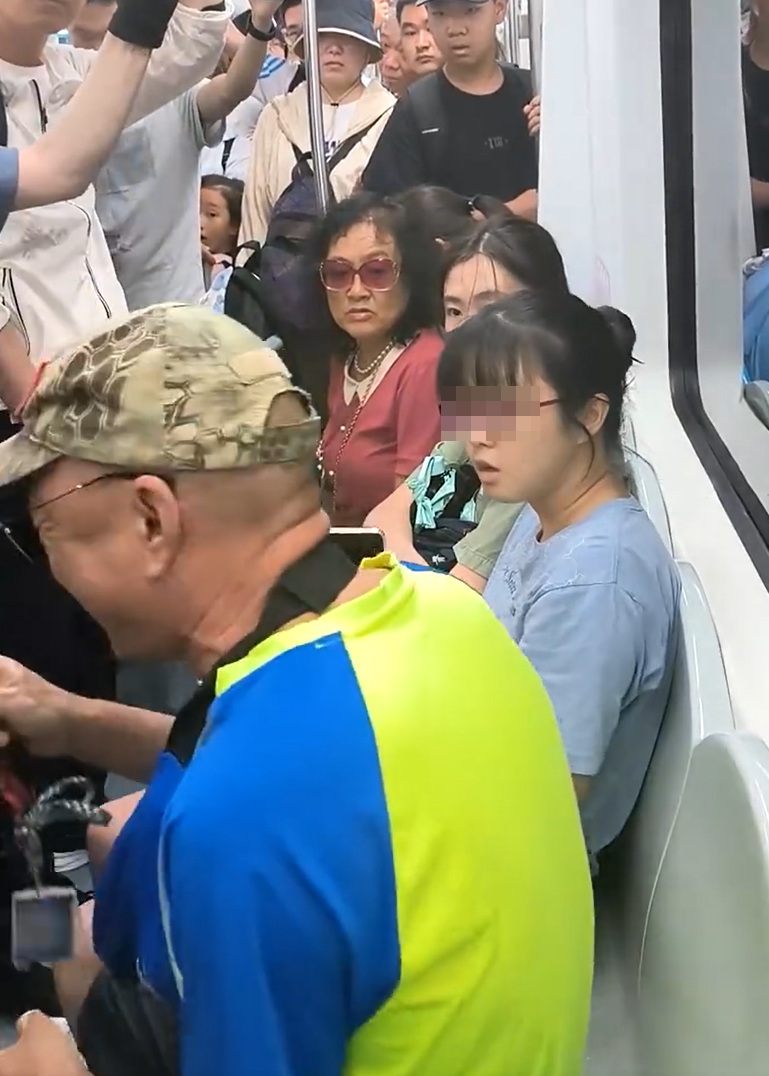 北京地鐵一名老翁不滿女乘客拒讓座,用枴杖狂撩女子雙腿中間來回「橫掃」。(影片截圖)