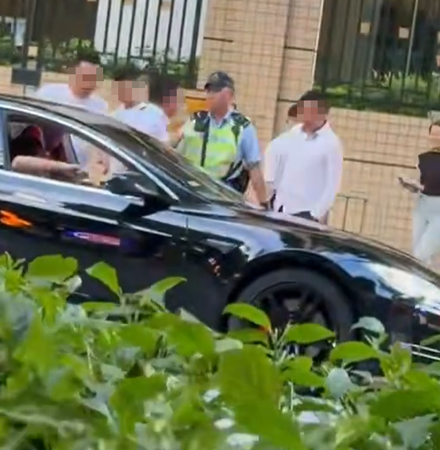 另一名穿白恤衫男子於車輛旁邊與警員理論,現場並有兩名白衣男(FB車cam L(香港群組))
