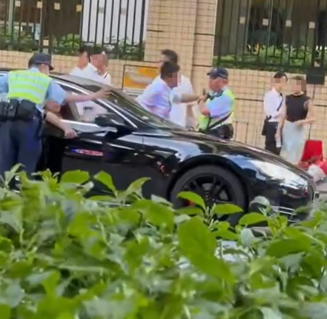 白衫男及後再度理論,惟該警員隨即撥開其手,往車輛前方再度極看及抄牌拍照做紀錄。(FB車cam L(香港群組))