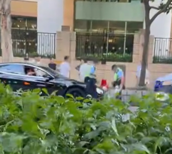 白衫男及後再度理論,惟該警員隨即撥開其手,往車輛前方再度極看及抄牌拍照做紀錄。(FB車cam L(香港群組))