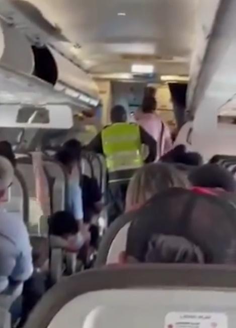 保安將該男童及其父親帶離飛機。(網上圖片)