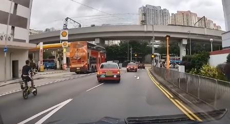 後方一名駕駛電動單車的黑衣男子被嚇窒駛離原本行車線,疑不滿的士切線。(車cam L(香港群組)@FB)