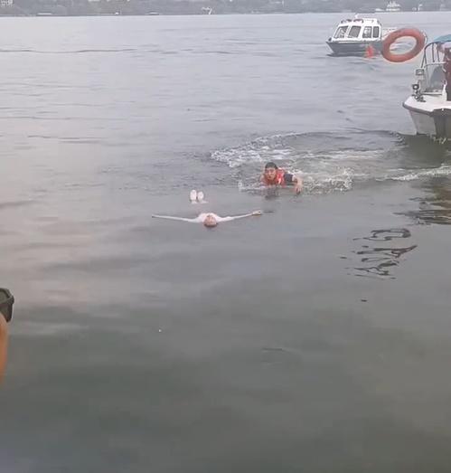 救援人員迅速將已落水3分鐘的女子救起,帶返岸上。(微博)