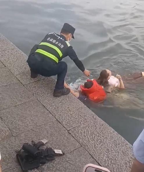 救援人員迅速將已落水3分鐘的女子救起,帶返岸上。(微博)