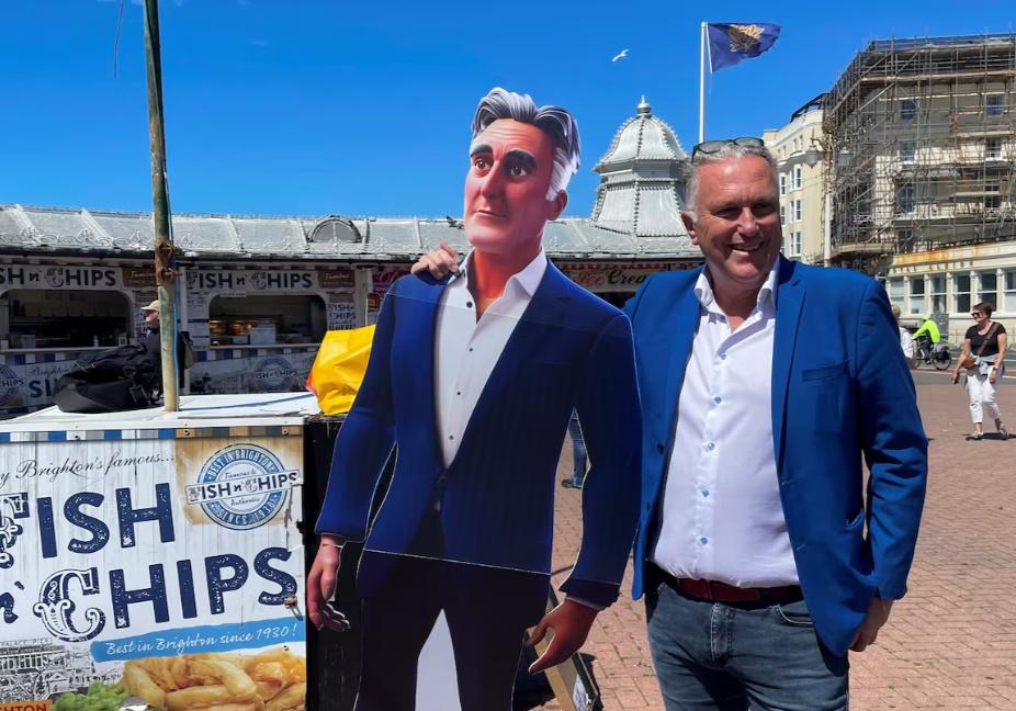 Steve Endacott周三(19日)帶同AI Steve的紙板肖像前往一個小鎮Brighton一個碼頭與選民見面。(網上圖片)