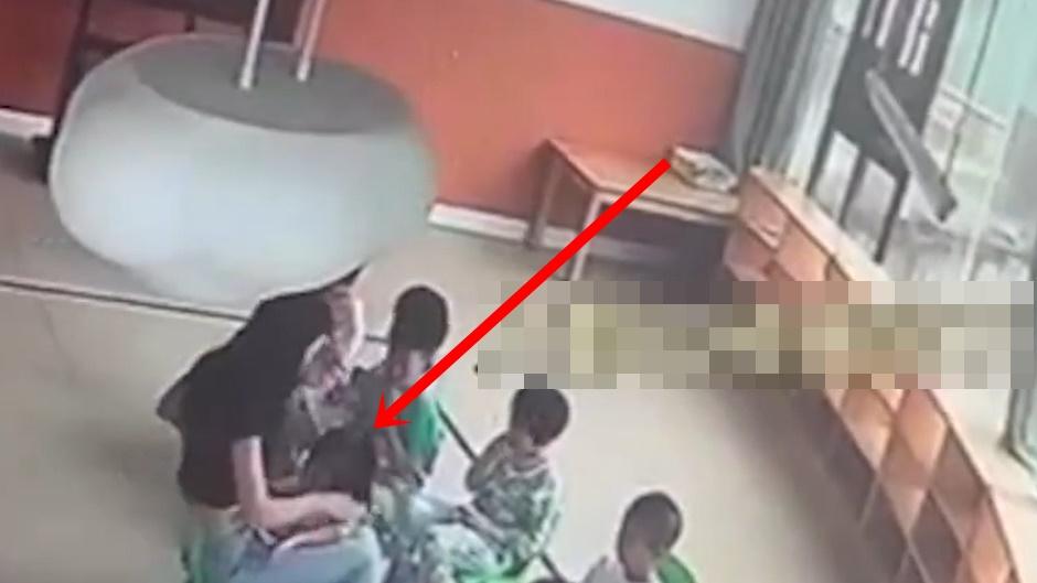 女童癱軟趴在老師腿上,老師仍未覺有異,只是將她扶起,並示意她自己去喝水。(微博)