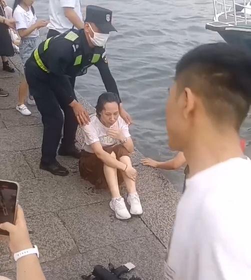救援人員迅速將已落水3分鐘的女子救起,帶返岸上。(微博)