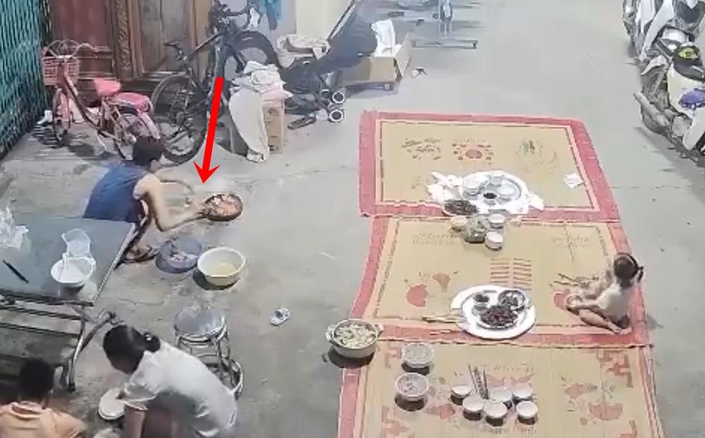 一名男子蹲在家門口用火盆煨魷魚,他使用酒精試圖增加火力。(X)