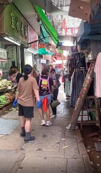 婦人拿起掃把打向其中一名女店員的腳部。(網片截圖)