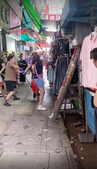 女店員在生果檔前擸起一把榴槤刀奔向婦人。(網片截圖)