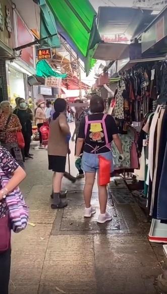 另一啡衫的女店員趁機搶走婦人手上掃把。(網片截圖)