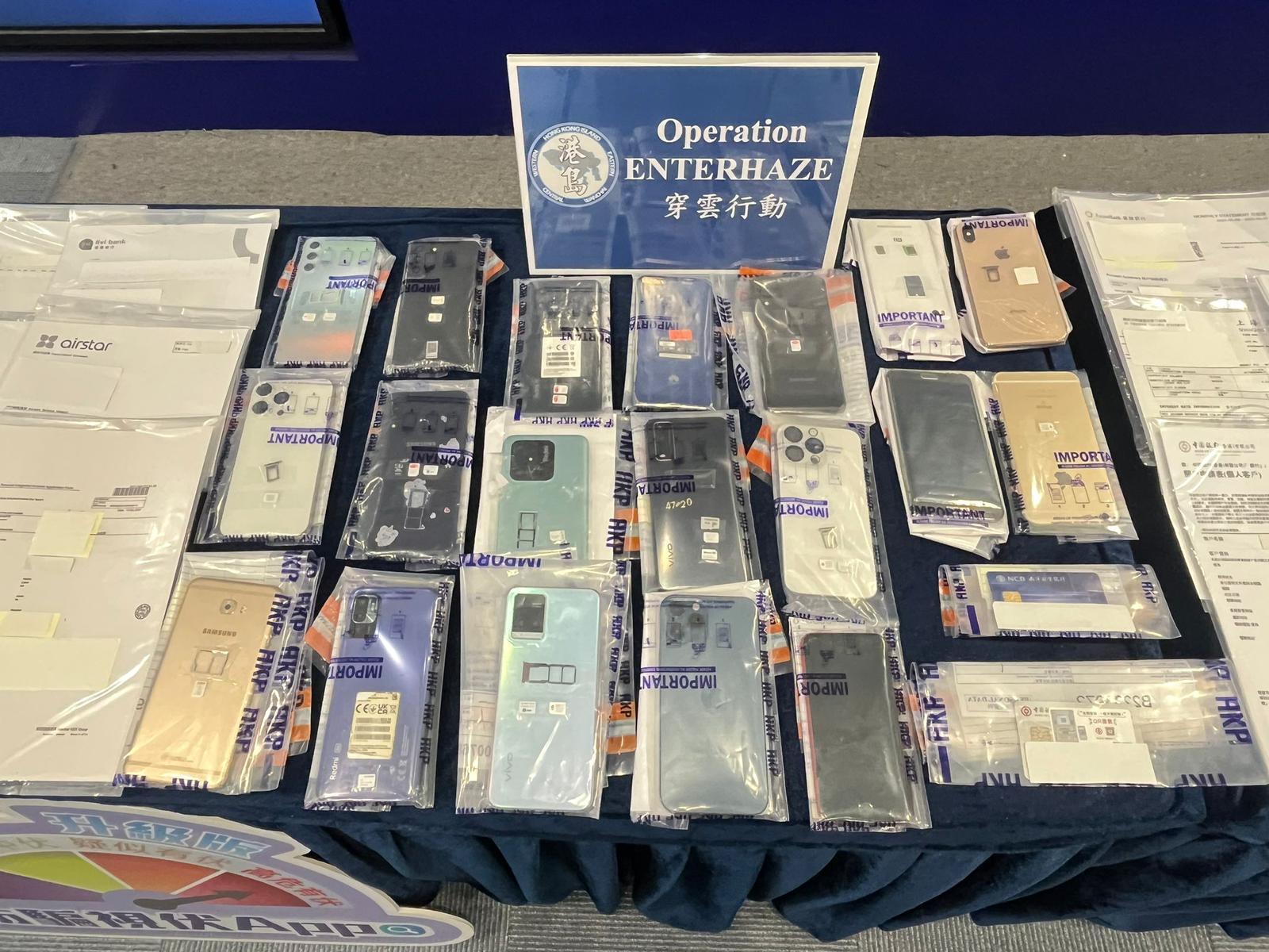 警方展示行動中檢獲的手提電話。