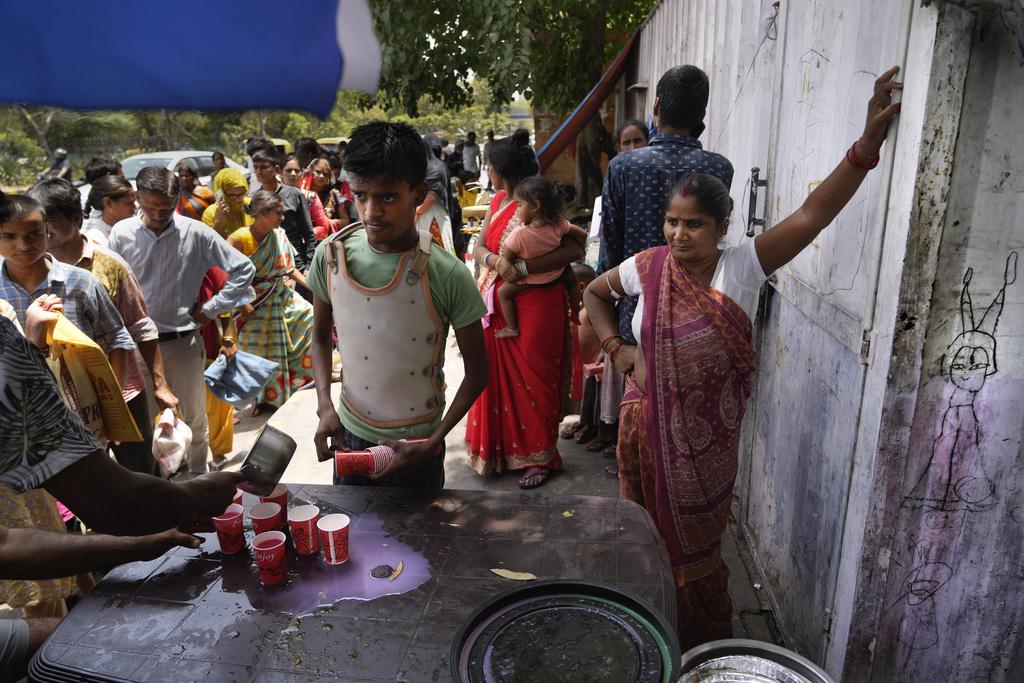 印度近日受到熱浪侵襲,有慈善團體在街頭派發冷飲,助居民消暑。(美聯社)