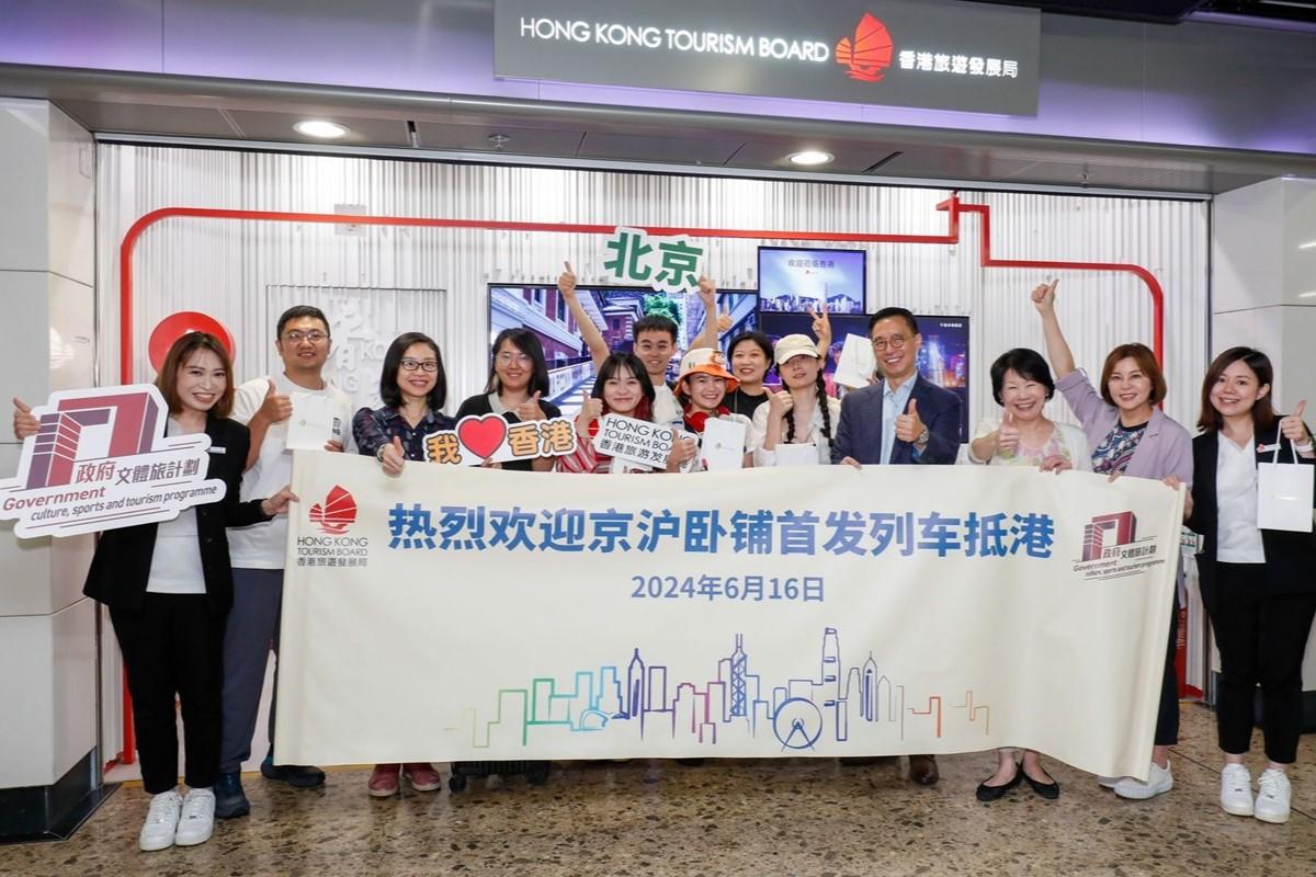 楊潤雄(右四)、旅遊事務專員沈鳳君(右三)等向抵港動臥列車旅客送上紀念品。(旅發局提供)