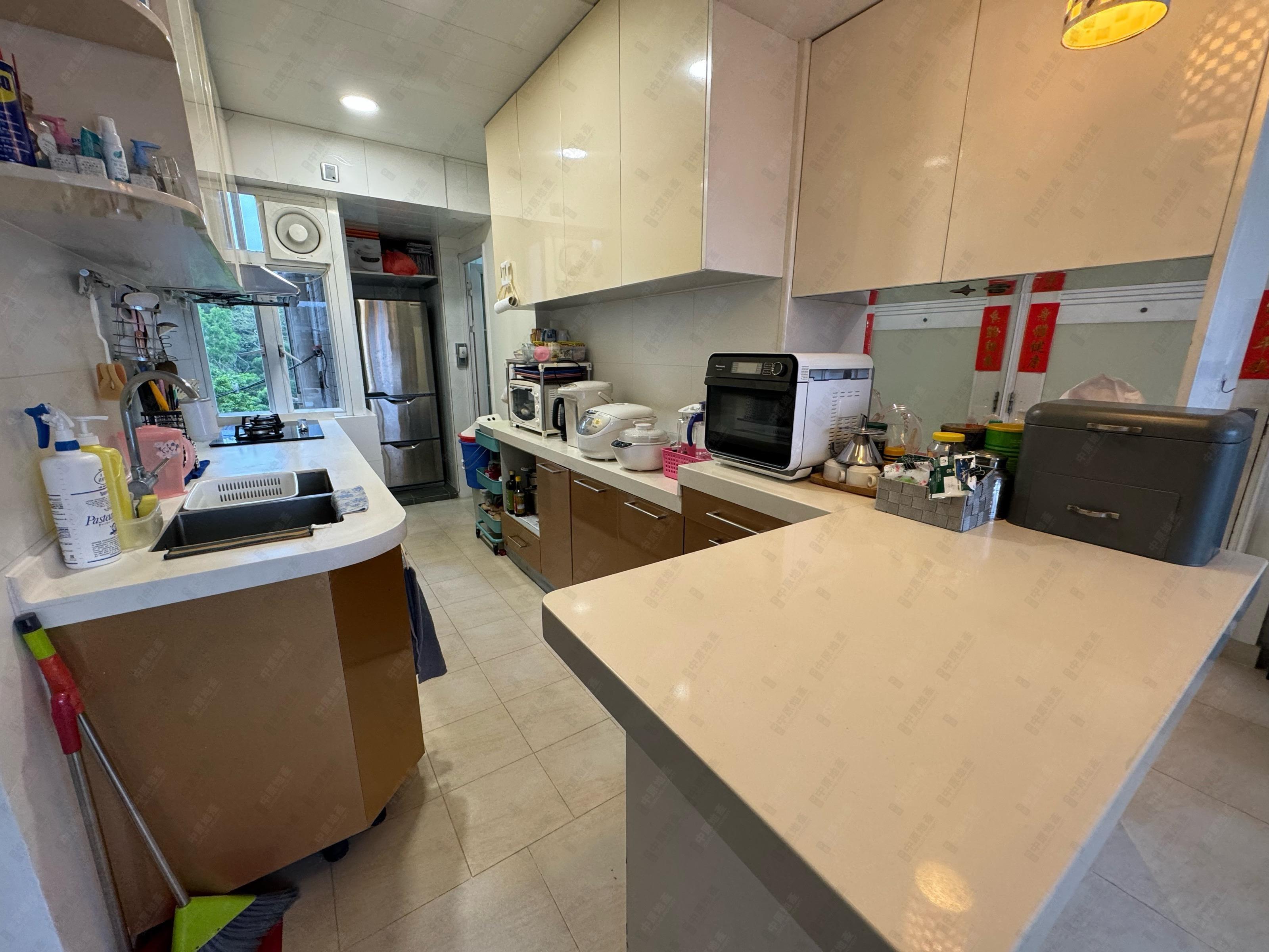 半開放式設計的廚房,設有中島櫃,十分實用。