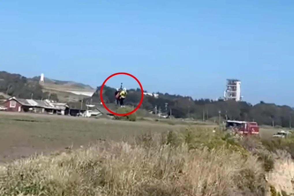 救援直升機把受困男子吊上峭壁上方的平地。(互聯網)