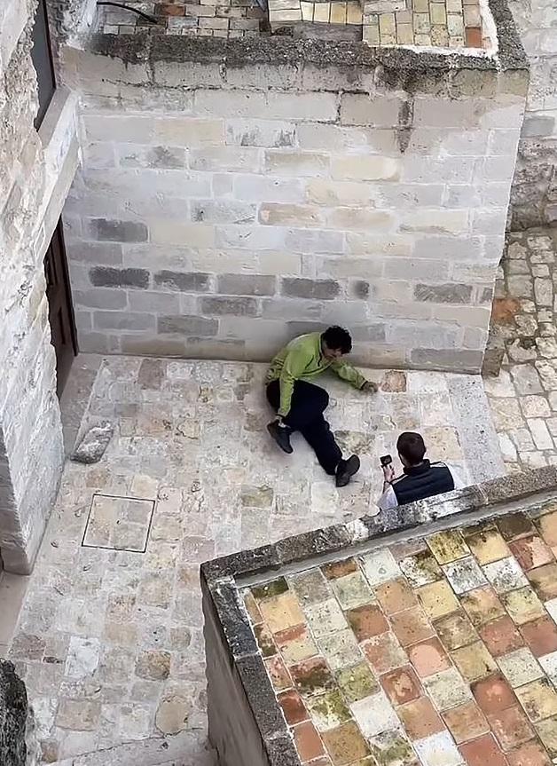 男子重摔在地,摸摸右腳,似乎疼痛。(互聯網)