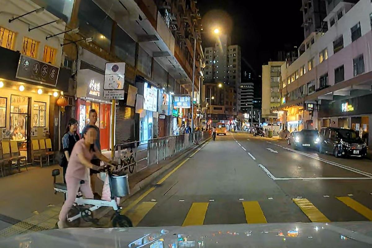 婦人在汽車剎停後徐徐從馬路後退回行人路。(網民Dan Hung@FB群組「車cam L(香港群組)」)