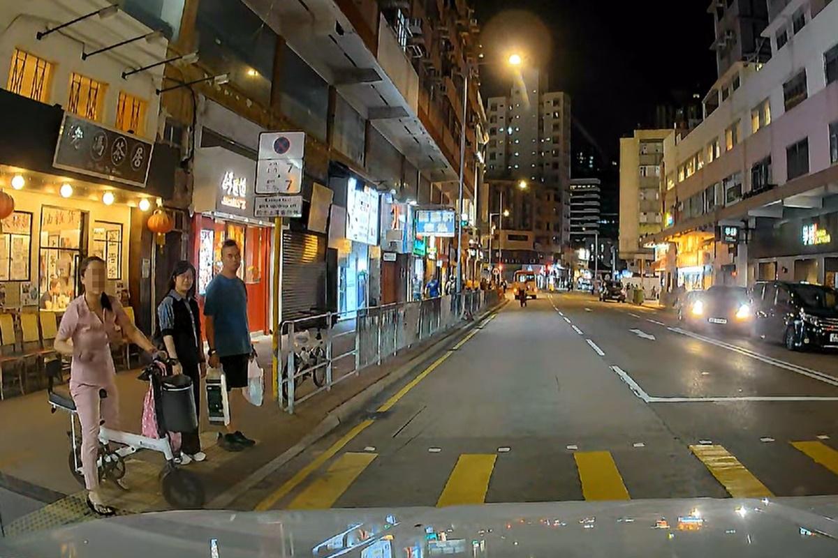 婦人在汽車剎停後徐徐從馬路後退回行人路。(網民Dan Hung@FB群組「車cam L(香港群組)」)