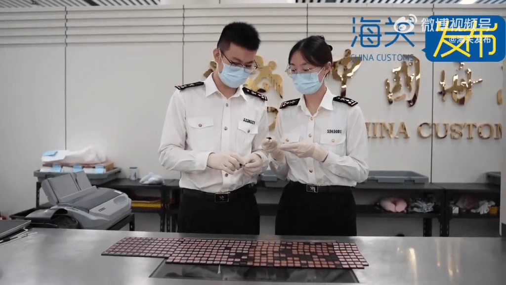 關員在點算從女子身上搜出的350張Switch遊戲卡。(海關發布)