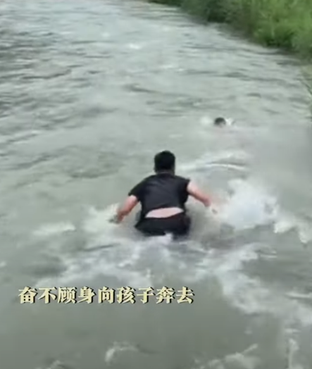 河北保定一名男孩於河邊滑倒被激流捲走,橋上一名大叔奮不顧身跳入水中,以「攔網式」將男孩救起。(影片截圖)