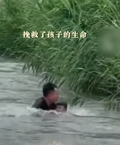 河北保定一名男孩於河邊滑倒被激流捲走,橋上一名大叔奮不顧身跳入水中,以「攔網式」將男孩救起。(影片截圖)