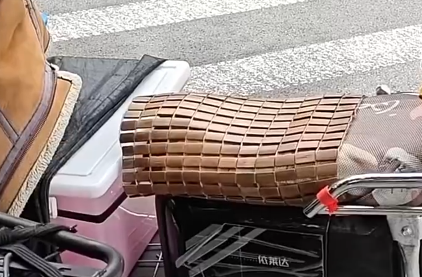 有市民為防止高溫的座鞍燙傷皮膚,在座位上鋪上涼蓆和防曬墊降溫(影片截圖)