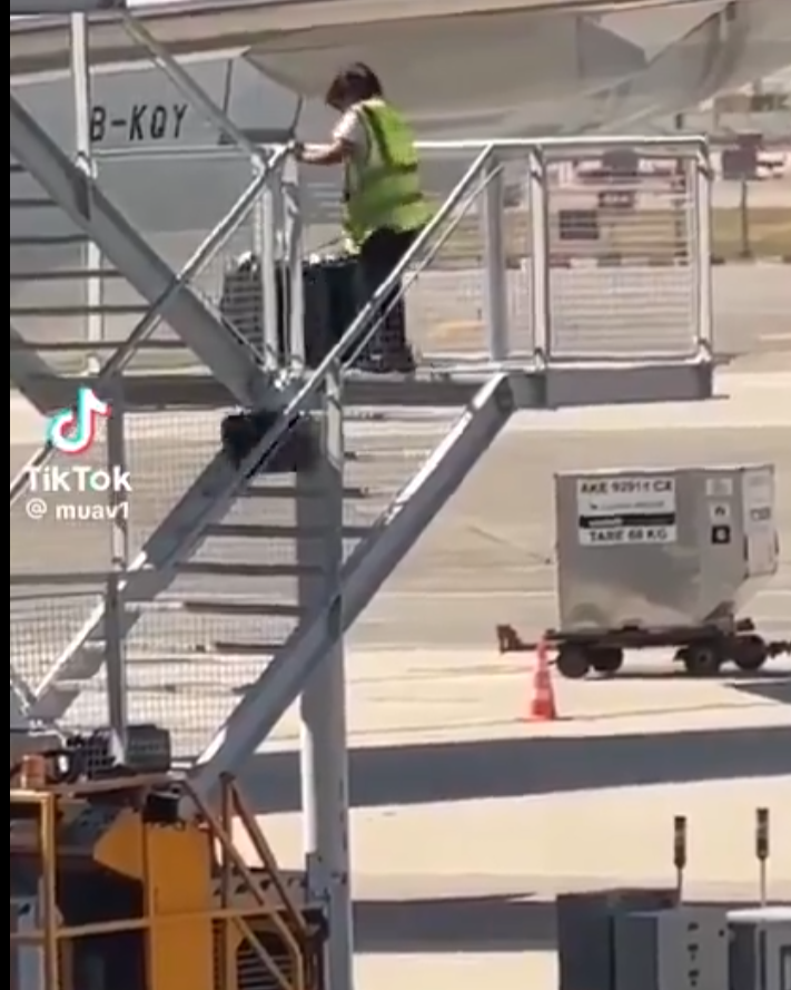 有影片顯示國泰航空的一名員工在機場多次從樓梯上把行李箱扔下(影片截圖)