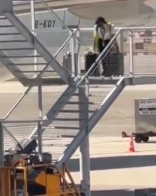 有影片顯示國泰航空的一名員工在機場多次從樓梯上把行李箱扔下(影片截圖)