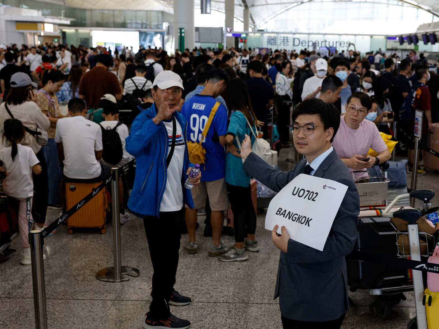 位於香港國際機場的自助辦理登機手續設施以及機場櫃位登機系統受到影響,航空公司為旅客人手辦理登機手續。(路透社)