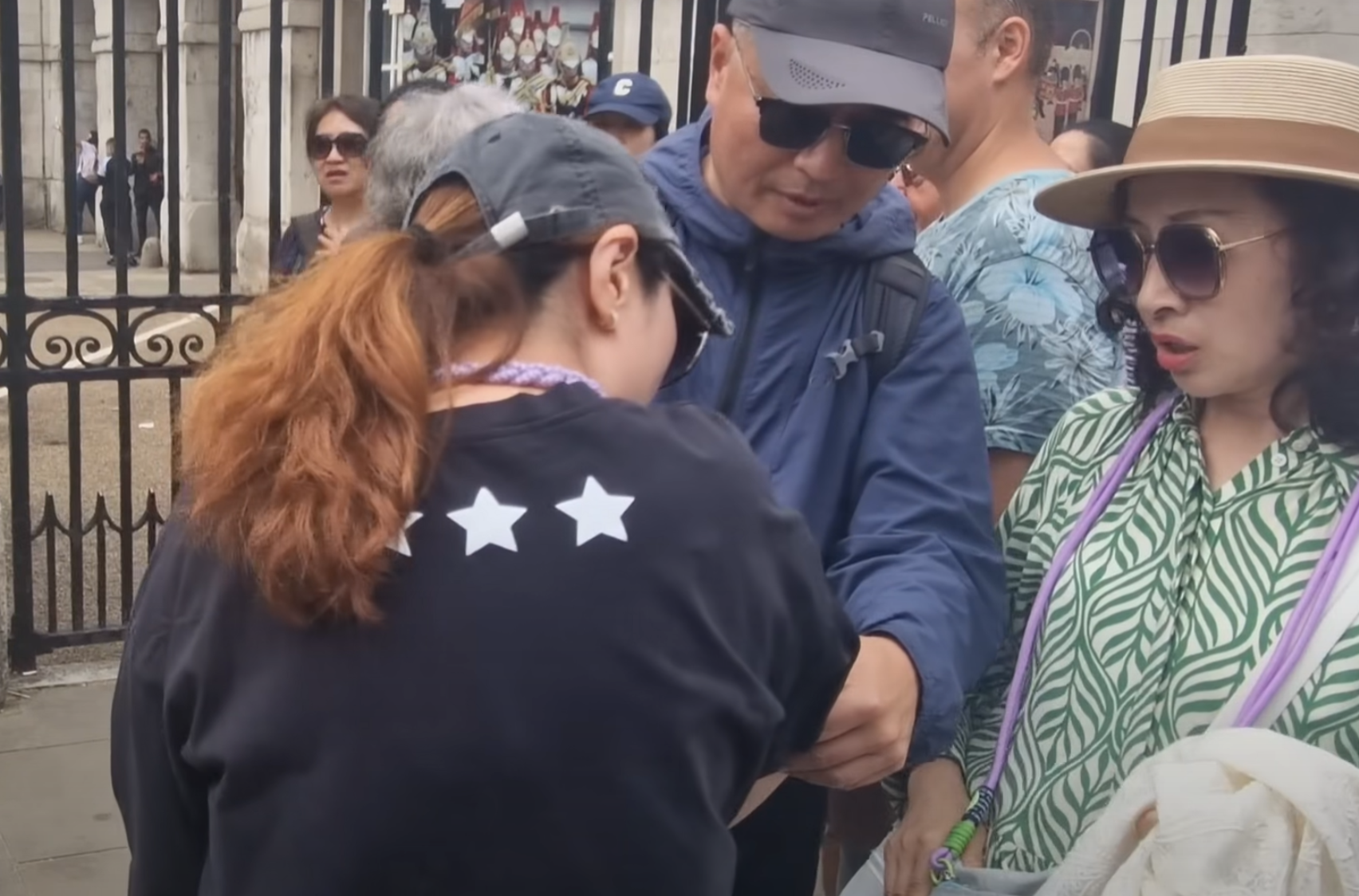 該名女遊客蹲在地上單手撐地,更在友人為其處理傷口時暈倒。(影片截圖)