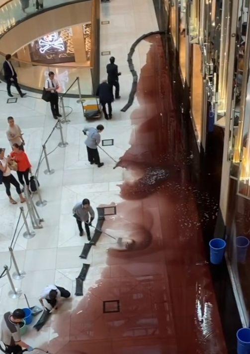 中環置地廣場地下中庭、近名店Dior門外有大片紅色液體傾瀉一地,影片及照片可見當時已有十多名清潔人員正在清理現場。