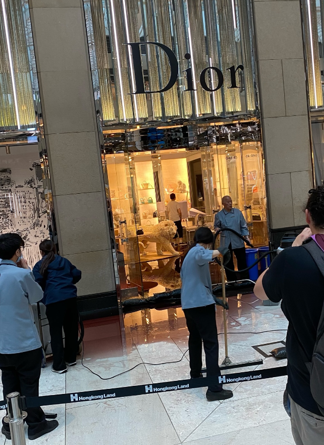 中環置地廣場地下中庭、近名店Dior門外有大片紅色液體傾瀉一地,影片及照片可見當時已有十多名清潔人員正在清理現場。