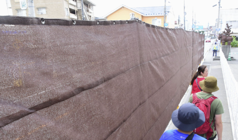 日本山梨縣富士河口湖町5月在當地一間LAWSON便利店對面架設巨型黑色布幕遮擋富士山景色,防止遊客為拍攝富士山而滋擾當地居民,不過很快黑布已被挖出多個洞。當地政府再有新措施,周四(25日)將黑布換成更堅固的棕色布料。