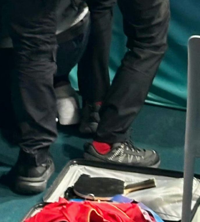 當王楚欽與孫穎莎舉起國旗時,身後一批攝影記者衝上前面拍攝,王楚欽放在一旁行李內的的球拍意外被踩斷。(網上圖片)