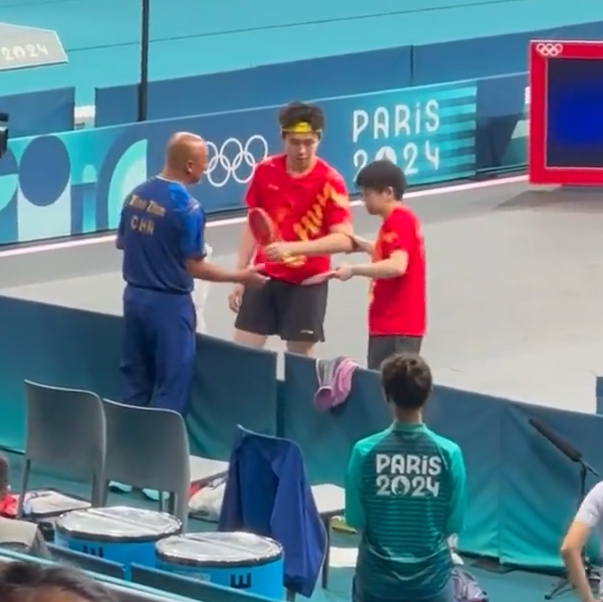 王楚欽得悉球拍被踩斷後神情失落及相當不滿,需教練安撫。(影片截圖)