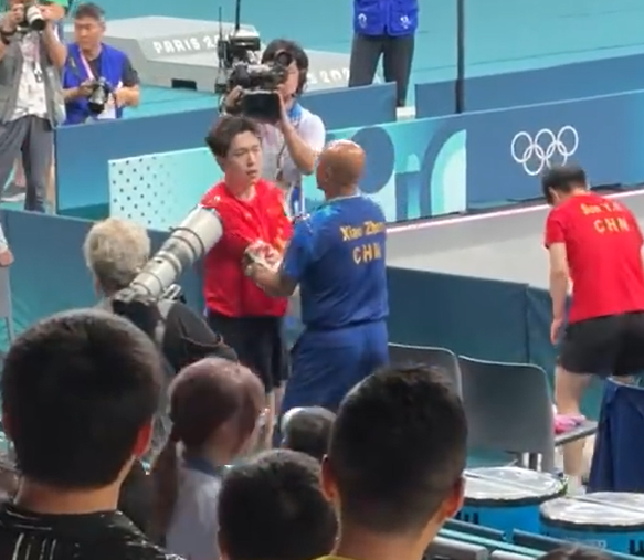 王楚欽得悉球拍被踩斷後神情失落及相當不滿,需教練安撫。(影片截圖)
